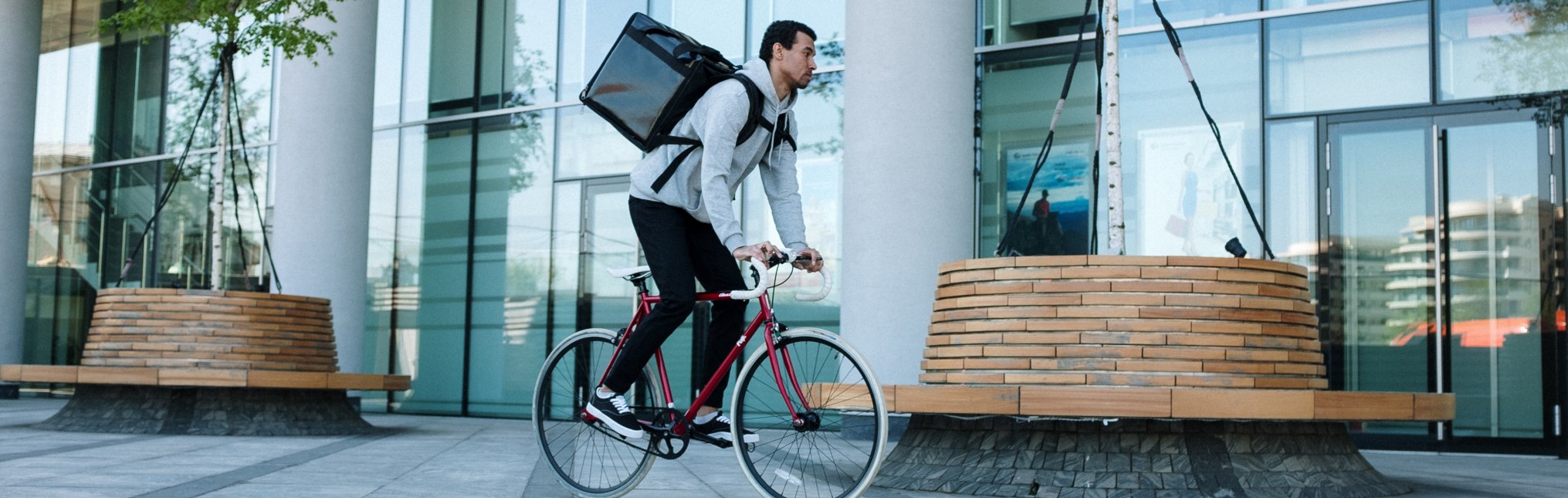 Man in White Long Sleeve Shirt and Blue Denim Jeans Riding on Black City Bike Delivering Food
